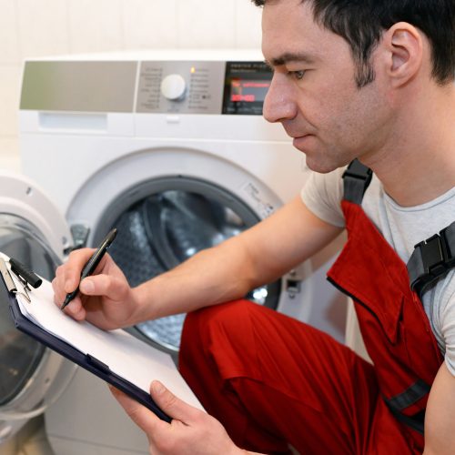 Techniker repariert Waschmaschine